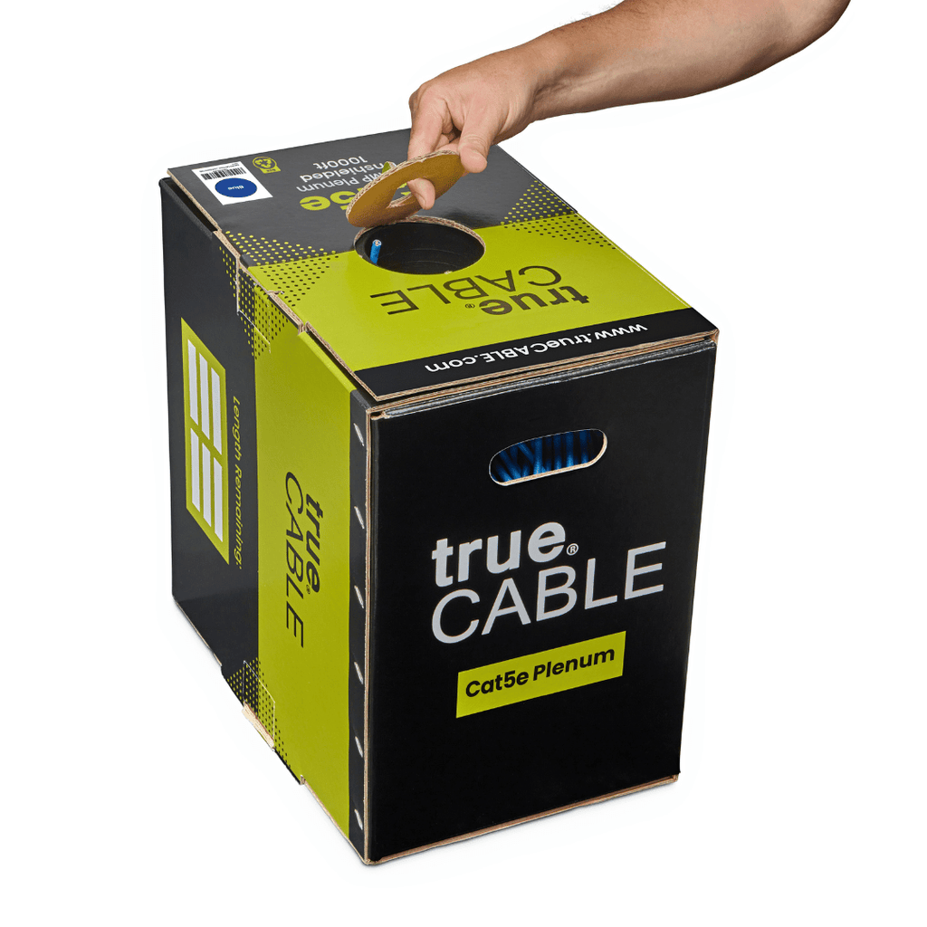 A hand lifting the "trueCABLE" box using its carrying handle, showing portability.